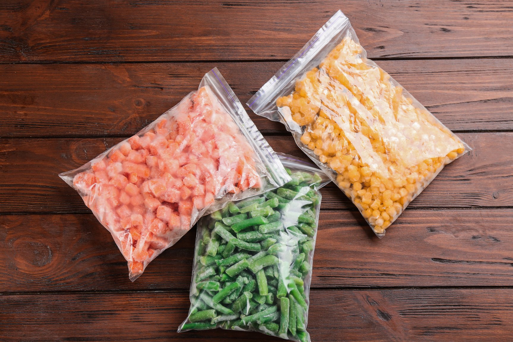 Different Frozen Vegetables on Wooden Table, Flat Lay