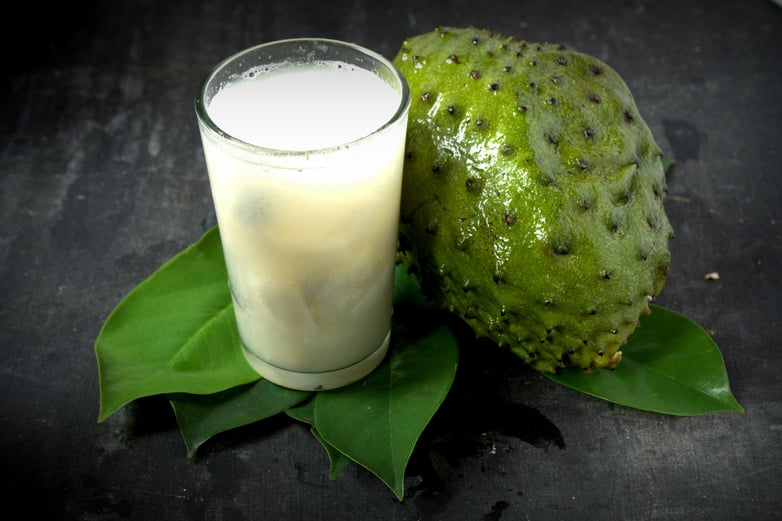 Soursop juice in glass with Fresh harvest soursop fruit